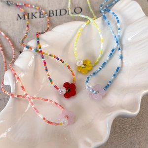 Colorful beaded flower necklaces in mermaid aesthetic on white shell dish display