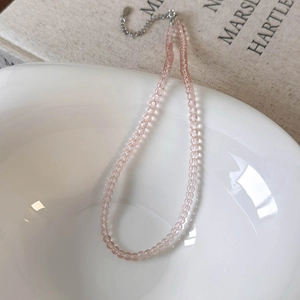 Detailed macro view of pink glass beaded necklace with silver lobster clasp and extension