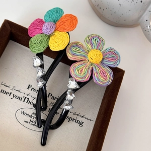 Vue détaillée des pinces à cheveux fleurs tissées arc-en-ciel avec strass en forme de cœur