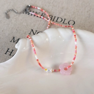 Close-up of colorful beaded floral necklace with shell tray and adjustable metal chain