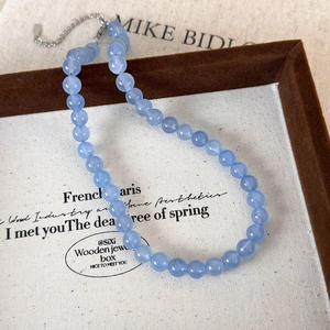 Detail of light blue beaded stone necklace with silver lobster clasp and extension chain