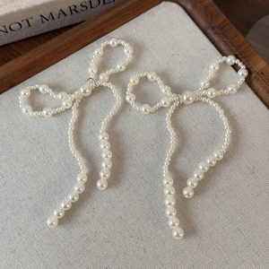 Détail de boucles de chaussures en perles artificielles en forme de nœud sur lin