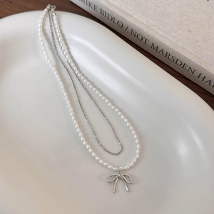 Collana a doppio strato con perle e catena d'argento con ciondolo a fiocco metallico