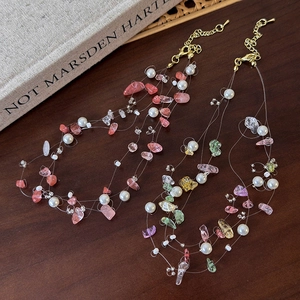 Detail of pink natural stone and pearl beaded necklace with gold lobster clasp