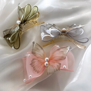 Close-up of elegant butterfly hair clips with organza wings and pearl details
