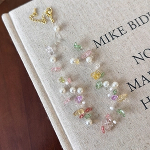 Detail of pink natural stone and pearl beaded necklace with golden lobster clasp and chain