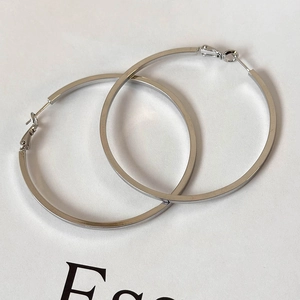 Detail showing high-polish silver hoop earrings with secure snap-back closure mechanism
