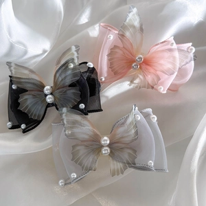 Detail of delicate organza butterfly hair clips with white faux pearl embellishments