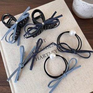 Ensemble de pinces à cheveux et élastiques en tissu denim bleu sur livre ancien
