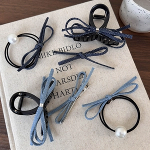 Détail de barrettes et chouchous en jean bleu avec perles sur fond rustique chic