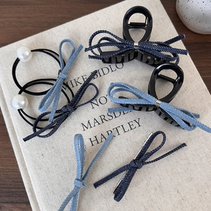 Vue détaillée de pinces à cheveux en denim et élastiques perles sur couverture de livre