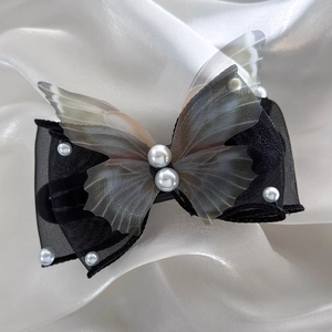 Detailed macro view of the mesh bow hairpin with elegant pearls and butterfly wings