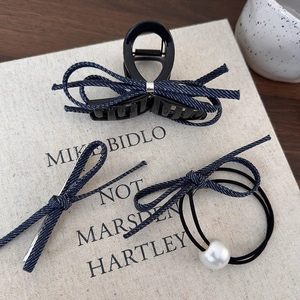 Détail d'un ensemble de barrettes en denim bleu et élastique perle sur un support