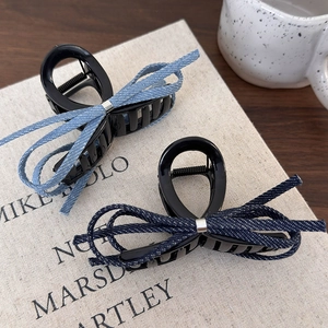 Ensemble de barrettes à nœuds en jean bleu posées sur un livre au style rétro