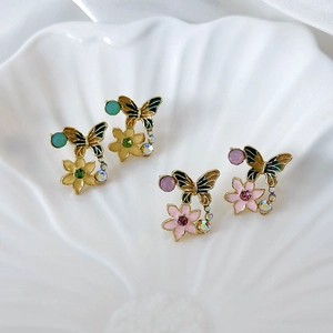 Detail of vintage enamel butterfly earrings with floral accents and colorful crystals