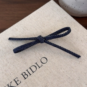 Vue détaillée de la barrette à cheveux en denim bleu foncé à pois blancs sur toile