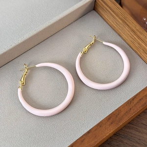 Close-up of sweet pastel pink hoop earrings with gold metal clasp in a jewelry box
