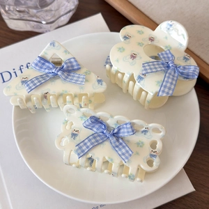 Tre fermagli per capelli crema con orsetti e fiocchi a scacchi blu su piatto bianco