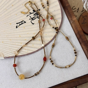 Zen style beaded necklace featuring natural stones and crystals on a calligraphy background