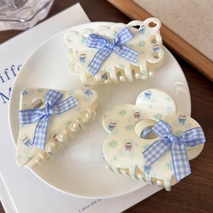 Dettaglio di tre mollette per capelli blu crema con orsetti e fiocchi a quadretti