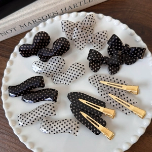 Vintage black and white polka dot hair clip set with resin bows and hearts in ceramic dish