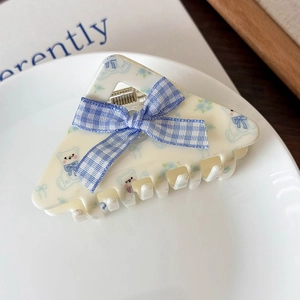 Dettaglio molletta per capelli crema con stampa orso blu e fiocco a quadretti