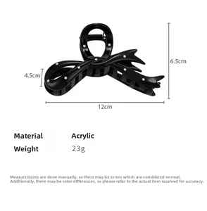 Detailed size view of black polka dot bow hair claw clip showing 12cm length and material