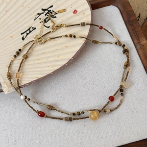 Detail of Zen style necklace featuring natural stones and multi-layered bronze beads