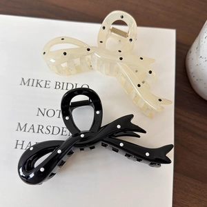 Polka dot bow hair claws in black and white styles on art magazine background