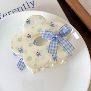 Dettaglio molletta per capelli a fiori con orsetti blu e un fiocco a quadretti