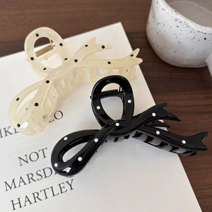 Close-up of bow hair claws with black and white polka dots and durable metal spring