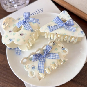 Set di 3 mollette per capelli con orsetto e fiori blu crema in un piatto bianco