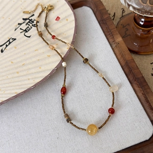 Close-up of Zen-style natural stone beaded necklace with red agate and tiger eye stones