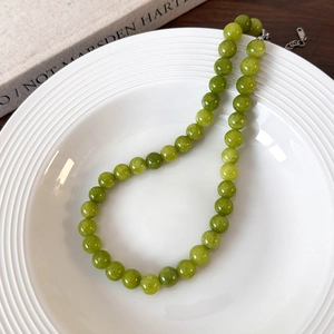 Close-up of green beaded necklace with natural stone beads and adjustable metal clasp