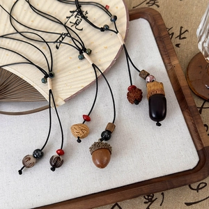 Détail du pendentif en céramique pignon avec cordon tressé sur un éventail vintage