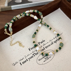 Close-up of green malachite beads and freshwater pearls on a luxury necklace