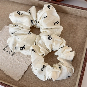 Set of two cream ballet style hair scrunchies with black bow patterns and rhinestones
