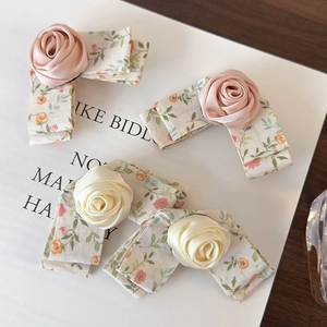 Handmade floral bow hair clips with satin roses for women on a decorative card