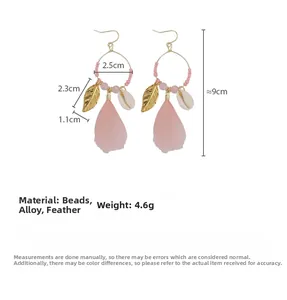 Detail view of pink feather earrings with size specifications and bohemian elements