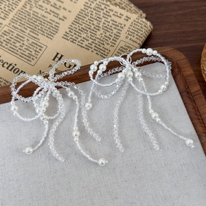 Détail de breloques de chaussures en perles et cristaux en forme de nœud fait main