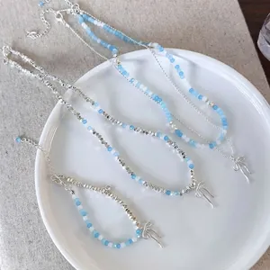 Handmade beaded necklace set with light blue pearls and silver bow pendants for women