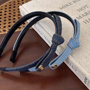 Close-up of blue denim bow headbands with golden metal buttons and non-slip inner teeth