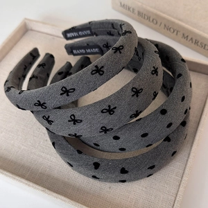 Three-piece set of wide grey fabric headbands with elegant velvet bows and heart patterns