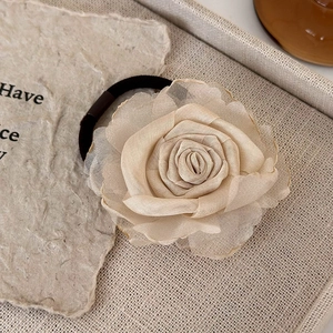 Detail of champagne organza rose hair tie with gold trim and high elasticity band