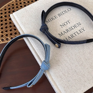Navy and light blue denim bow headbands with yellow stitching on vintage book background