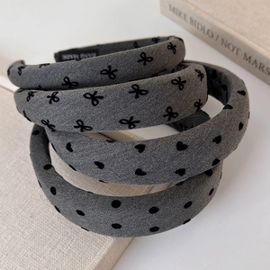 Set of four wide grey fabric headbands with black bow, heart, and polka dot patterns