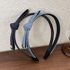 Detail of blue denim headbands with side knots, golden buckles and non-slip teeth texture