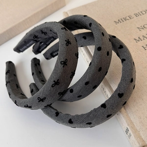 Detailed shot of grey thick headbands with bow and heart prints on vintage book props