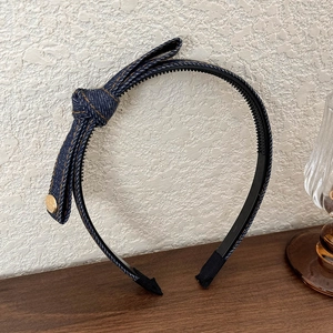 Blue denim headband featuring a side bow with yellow stitching and gold button detail