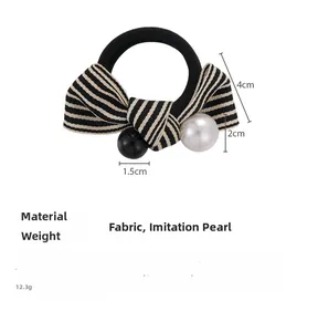 Close-up of bow hair tie with stripe pattern, pearl detail and size measurements